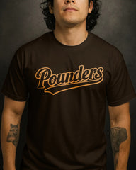 Man wearing a brown t-shirt with 'Pounders' printed on it against a dark background
